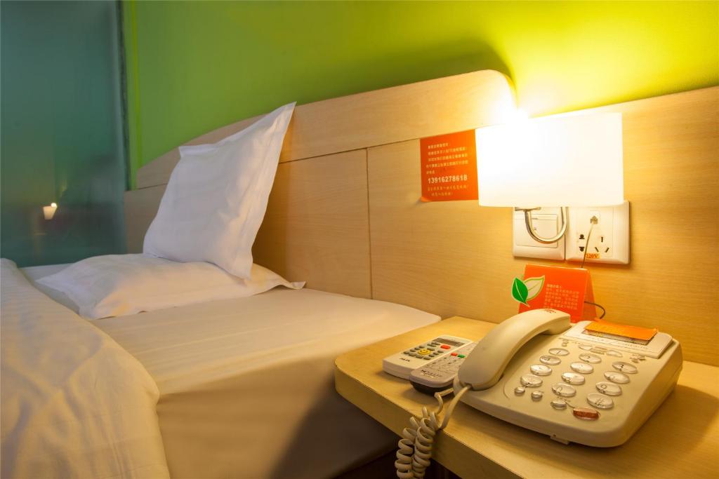 兰州7天连锁酒店兰州南关十字店的酒店客房配有电话和床。