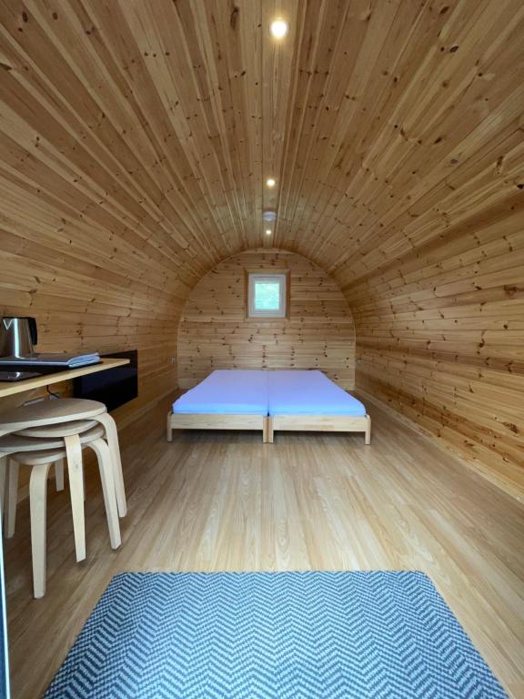 什鲁斯伯里Eastridge Glamping - Camping Pods的木制客房内的一间卧室,配有一张床