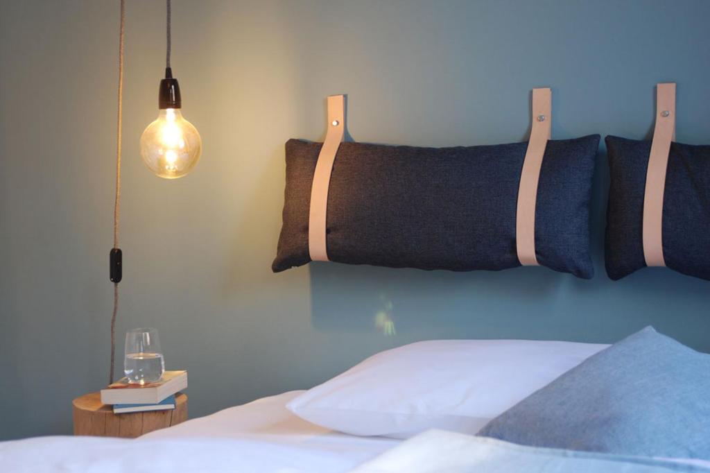 美茵河畔哈瑙Backsteinhaus Hanau的一间卧室配有一张带床头板和灯的床