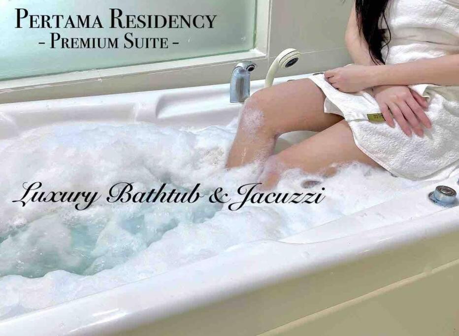 吉隆坡Staycation with Private Jacuzzi @ KL Downtown 1711的坐在浴缸里满水的女人