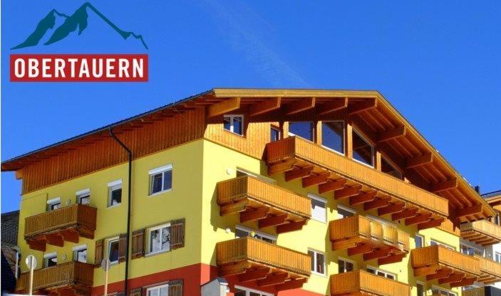 上陶恩alpsrental Apartments Freja Obertauern的黄色的建筑,上面设有阳台