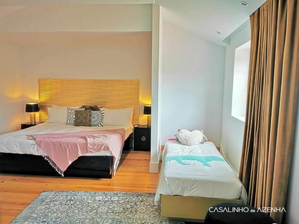 辛特拉Casalinho da Azenha - Charm House的一间卧室设有两张床和窗户。