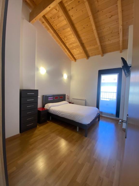 RodeznoVivienda de uso Turístico - La Garnacha的一间卧室配有一张床,铺有木地板