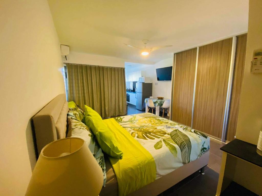 帕皮提Tehautahi Cozy Lodge 2的一间卧室配有一张黄色棉被的床