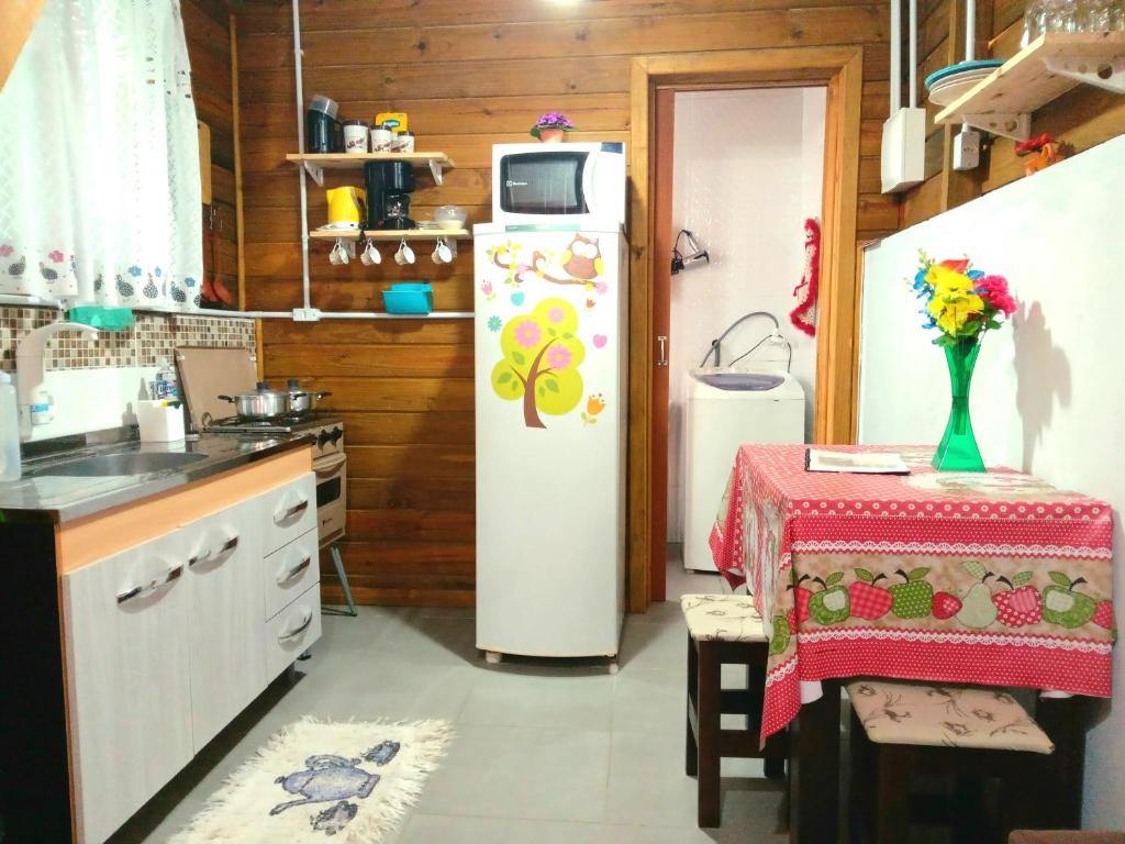 弗洛里亚诺波利斯Tiny House moçambique - Sua casinha em Floripa!的带冰箱和桌子的厨房