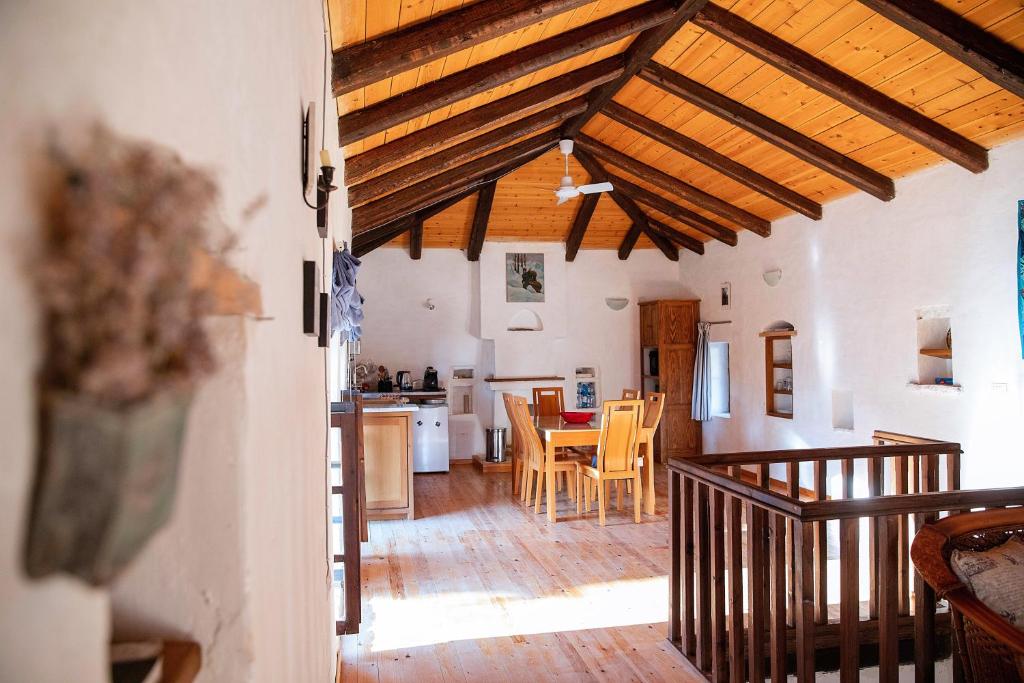 希马拉Rustic Holiday Villa Upper Qeparo的一间厨房和带木制天花板的用餐室
