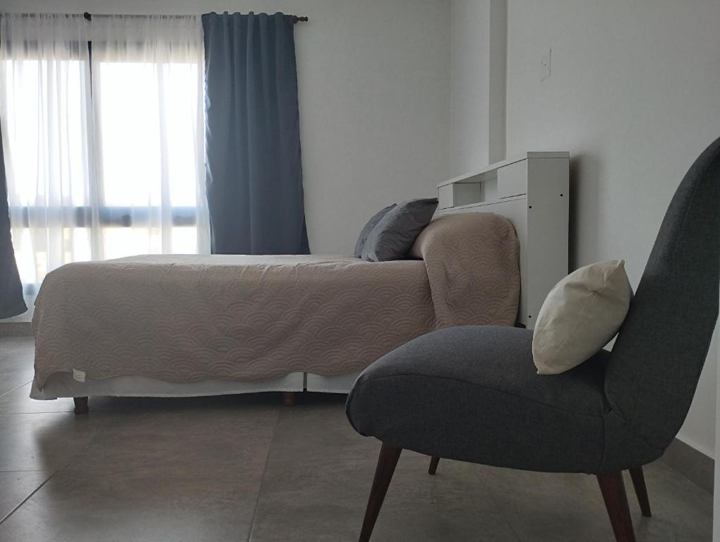 圣萨尔瓦多德朱Las Amapolas Jujuy的一间卧室配有一张床、一把椅子、一张床和窗户。