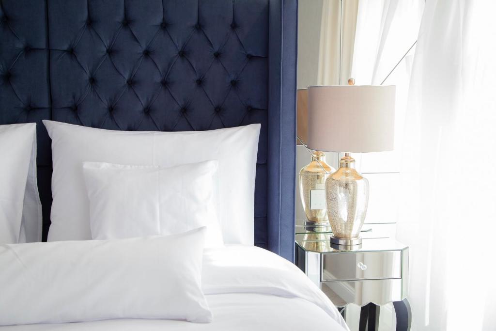 克塞洛Ibrahim Boutique Hotel的一间卧室配有一张带蓝色床头板和灯的床。