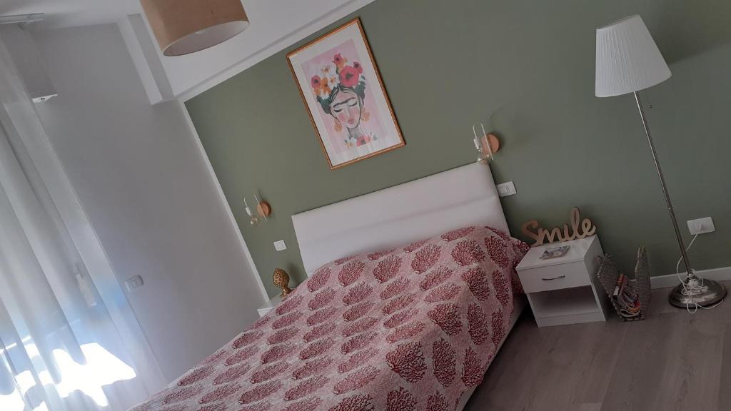 菲纳莱利古雷Casa di Kiki的小卧室配有一张带粉红色床罩的床