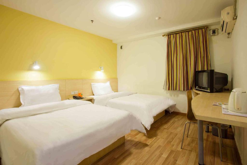 涪陵7天连锁酒店重庆涪陵南门山步行街店的酒店客房设有两张床和电视。