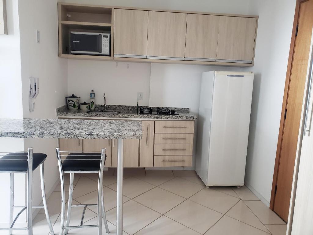圣卡洛斯Spot Residence São Carlos 700m da USP的厨房配有冰箱和带凳子的台面