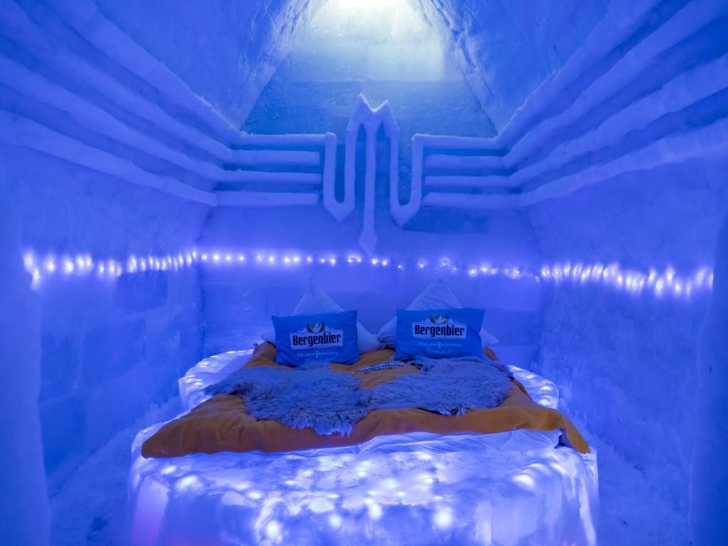 克尔茨什瓦拉乡Hotel of Ice Transylvania的蓝色的房间,床上灯火