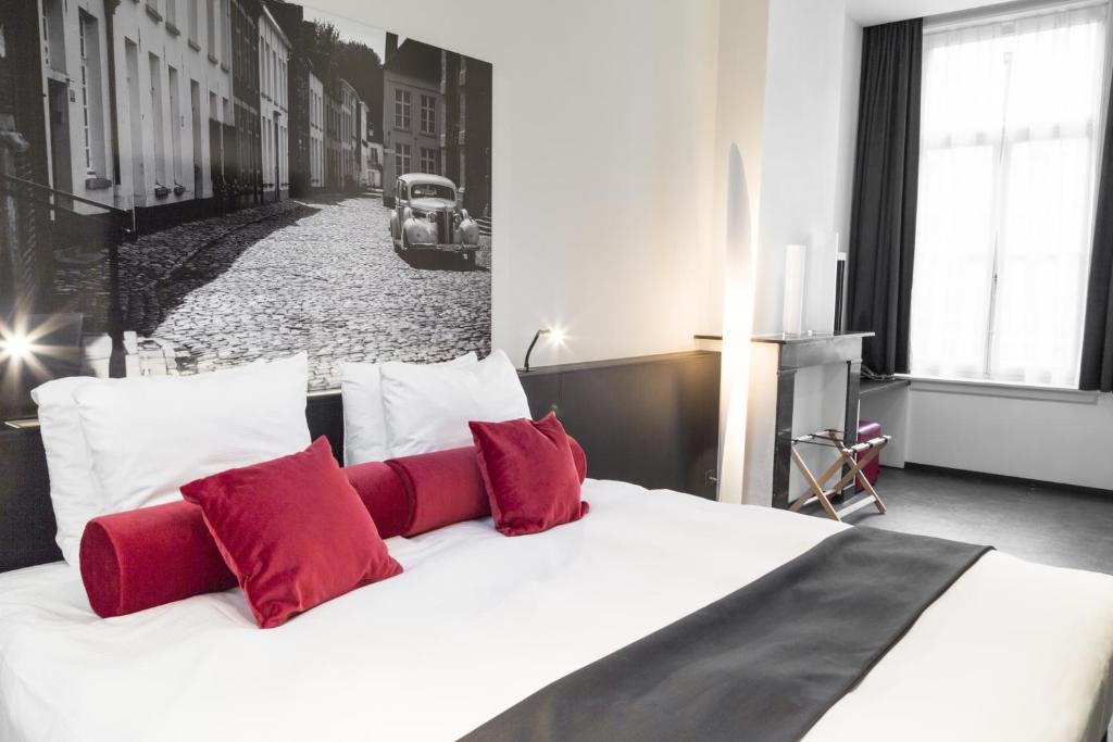 利尔Zimmerhof Hotel的卧室配有带红色枕头的白色床