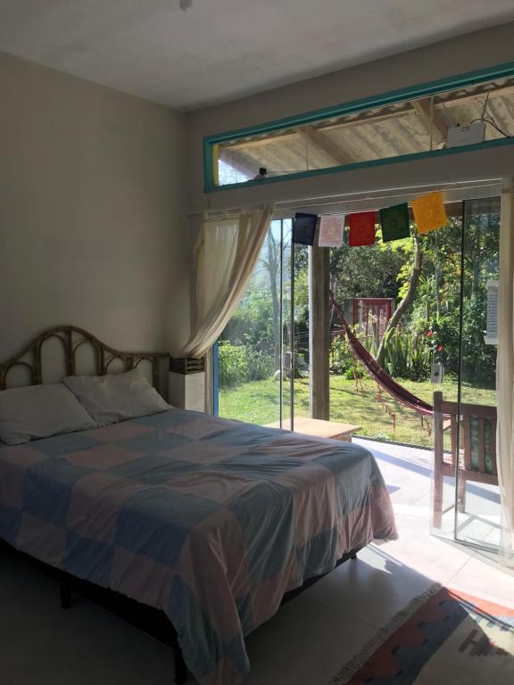 普腊亚罗萨Paikea Hostel Praia do Rosa的一间卧室设有一张床和一个大窗户