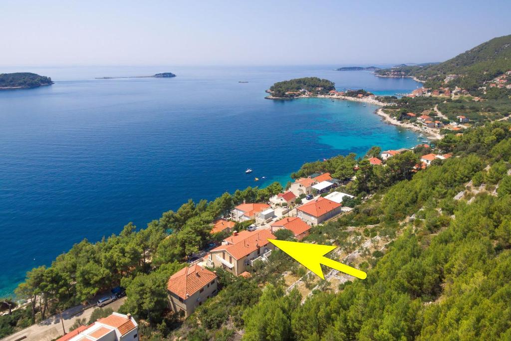 普利兹巴Apartments by the sea Prizba, Korcula - 9276的一座岛,上面有黄色箭头指向房子