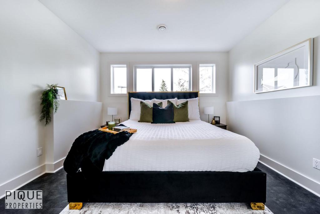 埃德蒙顿Stunning Modern Suite - King Bed - Free Parking & Netflix - Fast Wi-Fi - Long Stays Welcome的卧室配有一张带白色床单和枕头的大床。