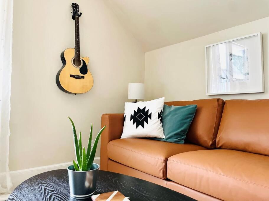 HawthorneImmaculate, Newly Renovated 1 Bedroom Apt Near NYC的客厅配有沙发和墙上的吉他