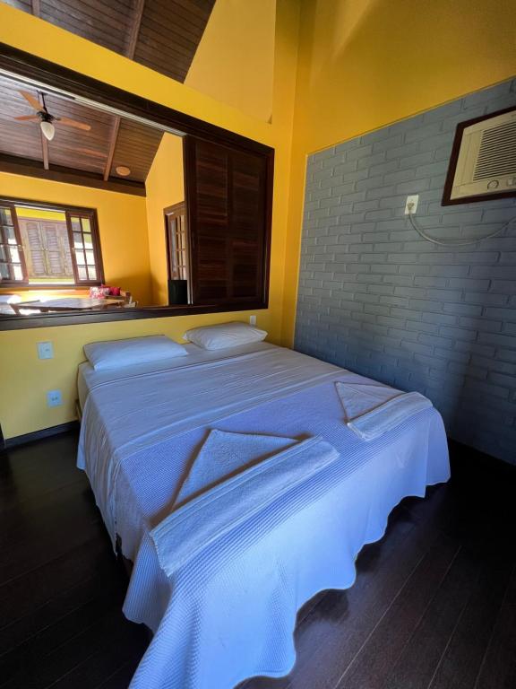 邦比尼亚斯Pousada Pacha Mama Village Bombinhas的一间卧室,卧室内配有一张大床