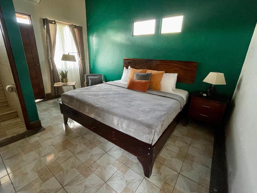 利比里亚Hotel Wilson Condega的一间卧室配有一张带绿色墙壁的床