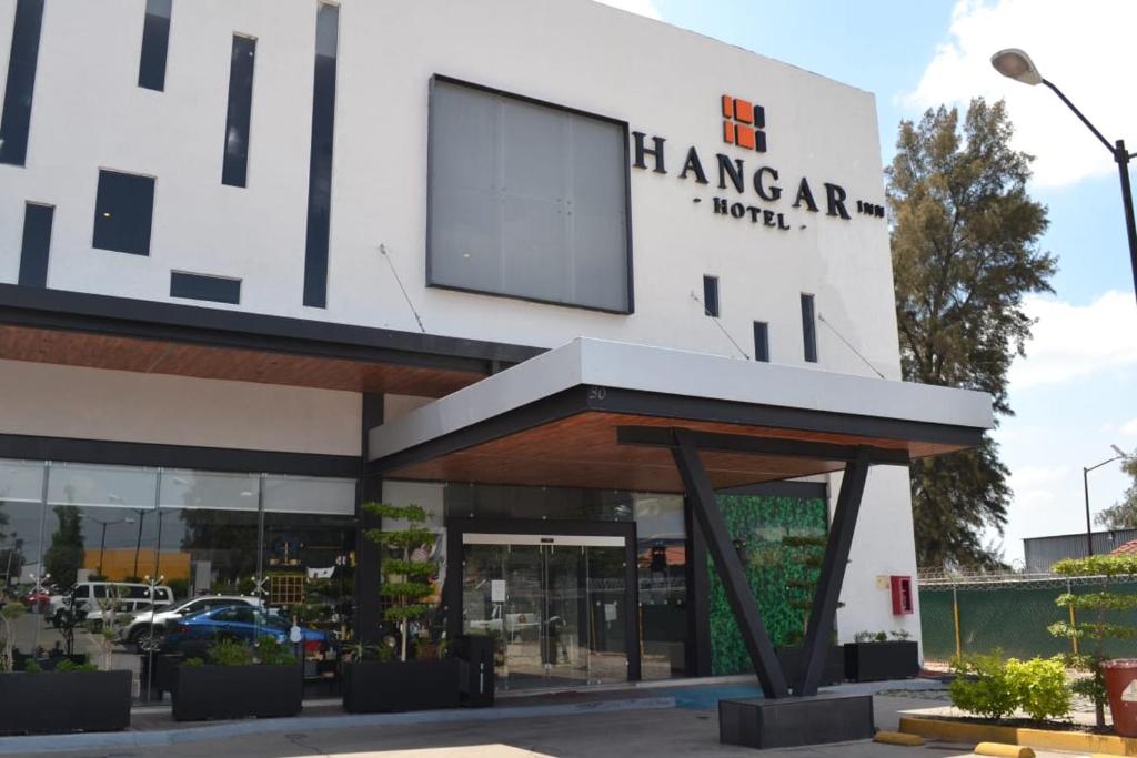 瓜达拉哈拉Hangar Inn Guadalajara Aeropuerto的一座白色的大建筑,上面有标志