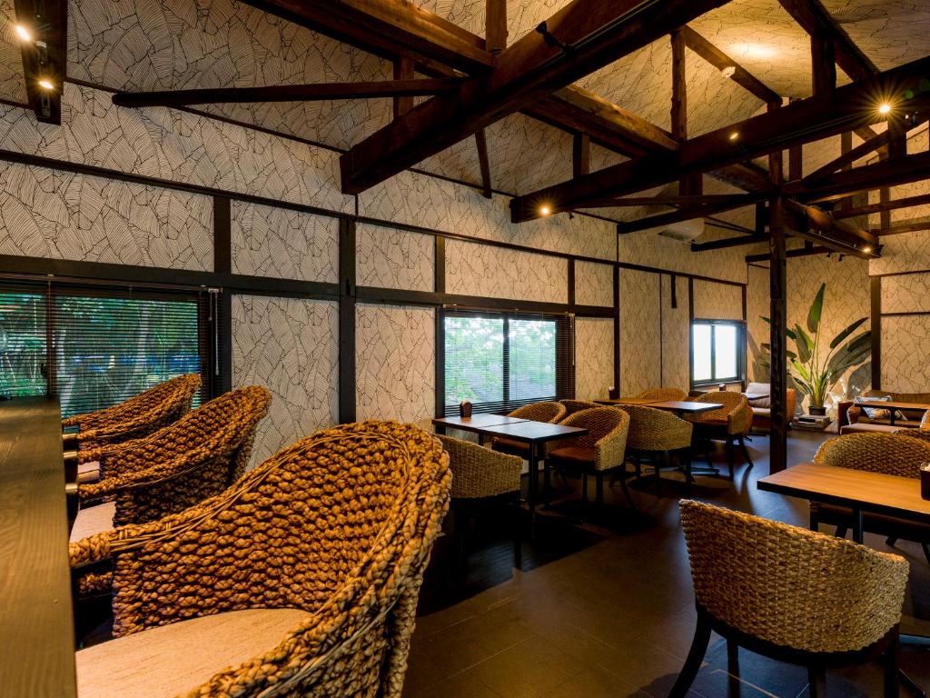 大岛癒楽 伊豆大島的餐厅设有藤椅、桌子和窗户。