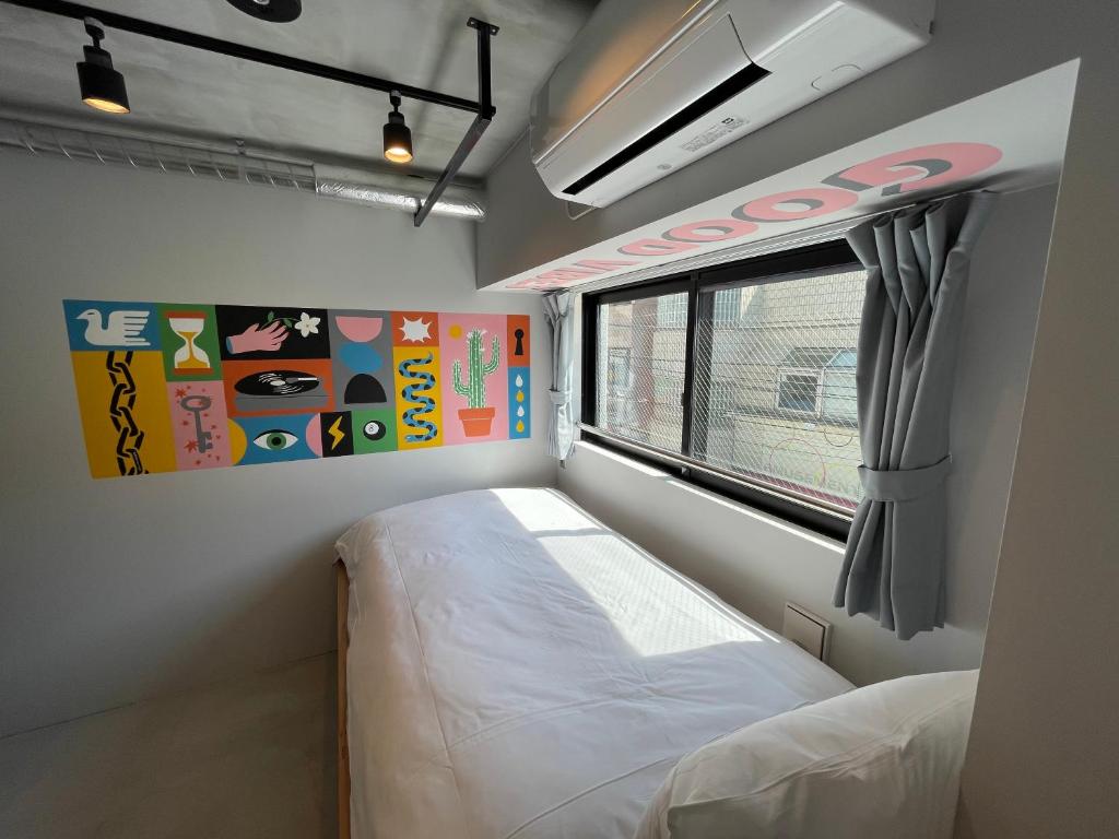东京ART HOTELS SHIBUYA的小房间设有床和窗户