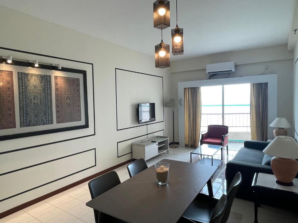 丹绒武雅Seaview Suite at Rainbow Paradise的客厅配有桌子和沙发