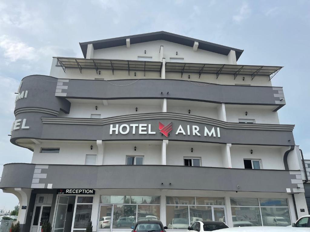 SurčinAirMi hotel的一座位于酒店前方的农庄建筑,其前方设有停车场