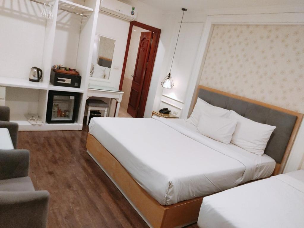 河内Khách Sạn A83Hotel的一间卧室设有两张床和一个壁炉