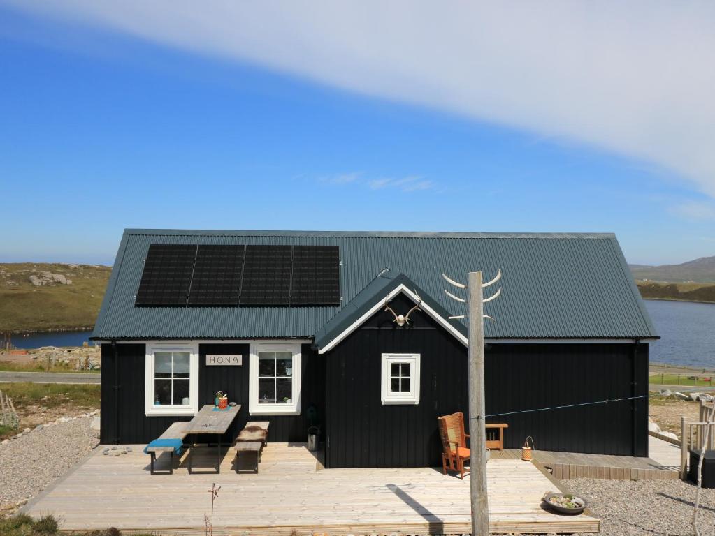 MangerstaHona的屋顶上设有太阳能电池板的黑色房子