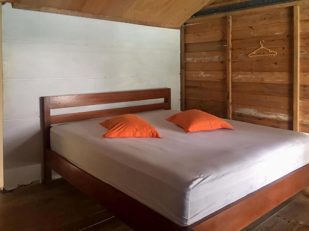 班达亚齐Olala Bungalows And Restaurant Mitra RedDoorz的一张带两个橙色枕头的床