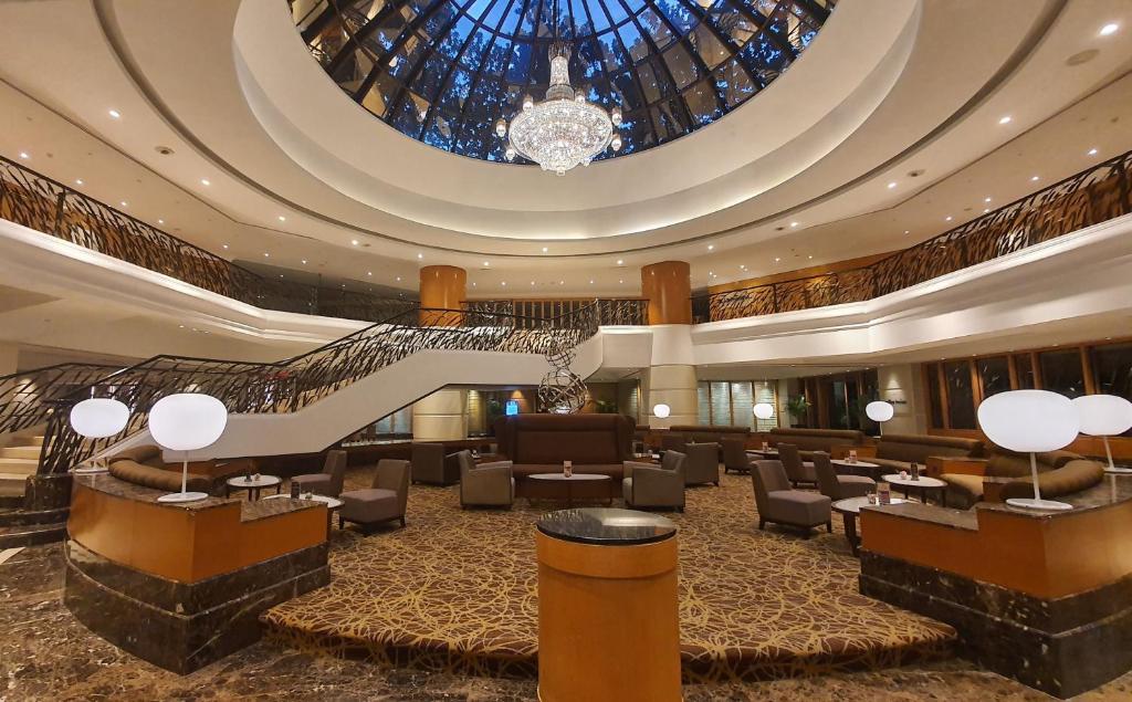 吉隆坡Sunway Putra Hotel Kuala Lumpur的酒店大堂设有楼梯和大型天花板