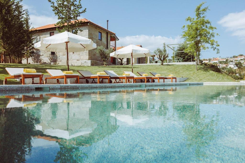 阿马兰特Oliveiras Village — Agroturismo的房屋旁的游泳池配有椅子和遮阳伞