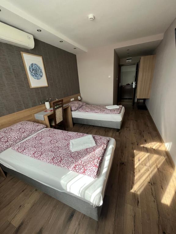 埃尔德波尔哈中央 - 伊特利姆畔兹奥旅馆的铺有木地板的客房内的两张床