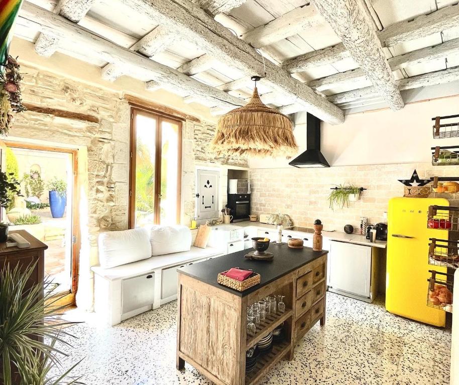 沃韦尔La Maison du Trident en Camargue Piscine et Jacuzzi的厨房配有黄色冰箱和台面