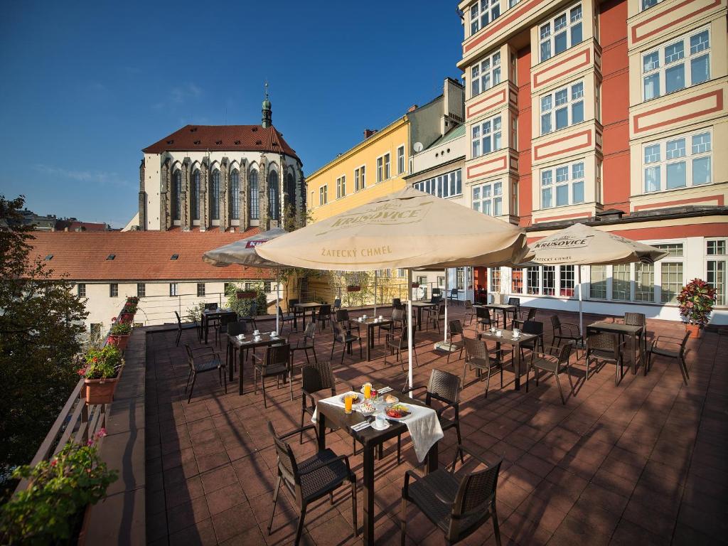 布拉格EA朱莉斯酒店的一个带桌椅和遮阳伞的庭院