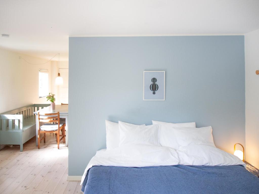 斯泰厄Kamilla's cottage, 1 km. from the beach的一间带蓝色和白色床的卧室以及一间用餐室