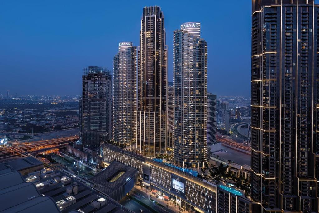 迪拜Address Dubai Mall的一群高大的建筑在晚上在城市里