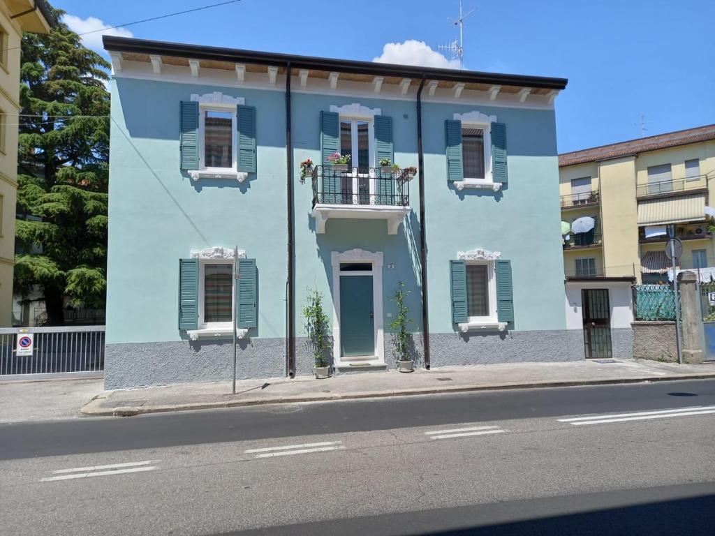 维罗纳Mercante In Fiera的蓝色的建筑,设有白色的窗户和阳台