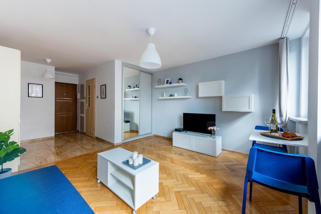 华沙Śliska 10 Prywatne mieszkanie 300m od Dworca Centralnego oraz metra ONZ的客厅配有桌子和蓝色椅子