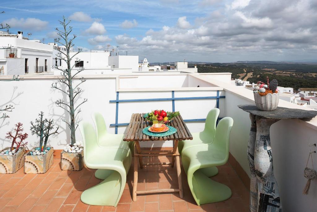 贝赫尔-德拉弗龙特拉La Casuca的阳台配有木桌和绿色椅子