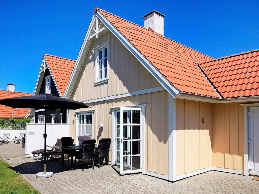 布拉万德4 person holiday home in Bl vand的房屋配有桌椅和遮阳伞
