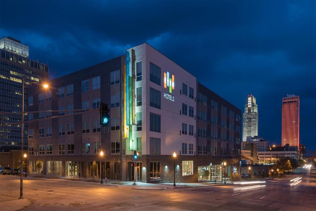 奥马哈EVEN Hotel Omaha Downtown - Old Market, an IHG Hotel的城市的建筑,夜晚有绿灯