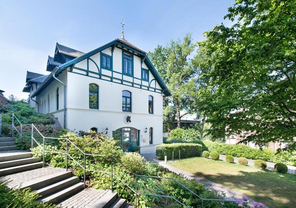 汉堡Das Elbcottage - Remise am Süllberg - Boarding House的蓝色屋顶的白色房子