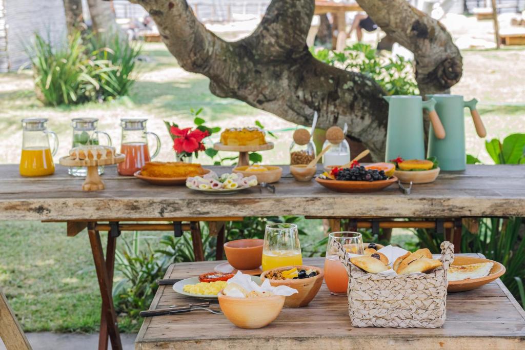 卡拉伊瓦Pousada Quintal Caraíva的一张野餐桌,上面有食物和饮料