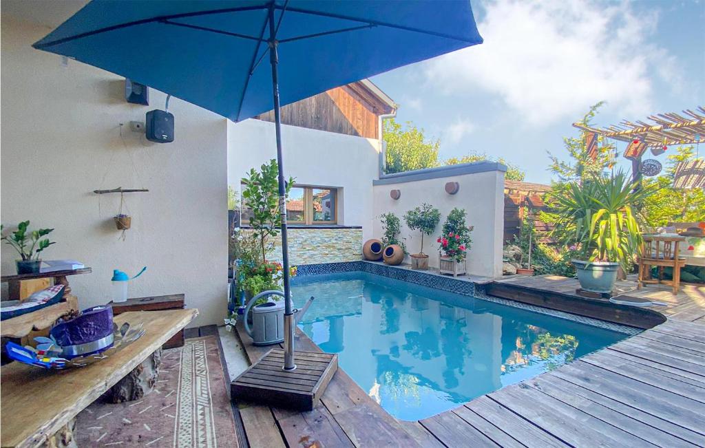 米泰尔贝尔甘Lovely Home In Mittelbergheim With Kitchen的一座房子旁带遮阳伞的游泳池