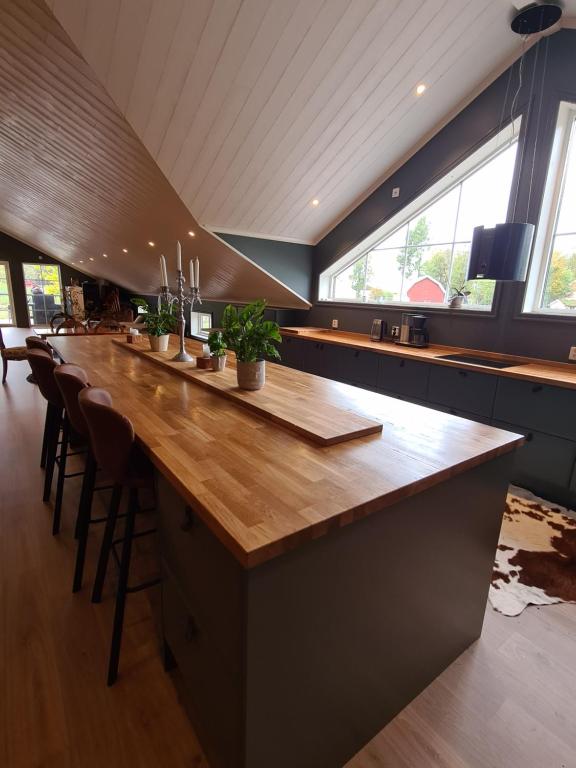 LjungMysig lägenhet med öppen planlösning på hästgård.的一个大厨房,内设一个带凳子的长木酒吧