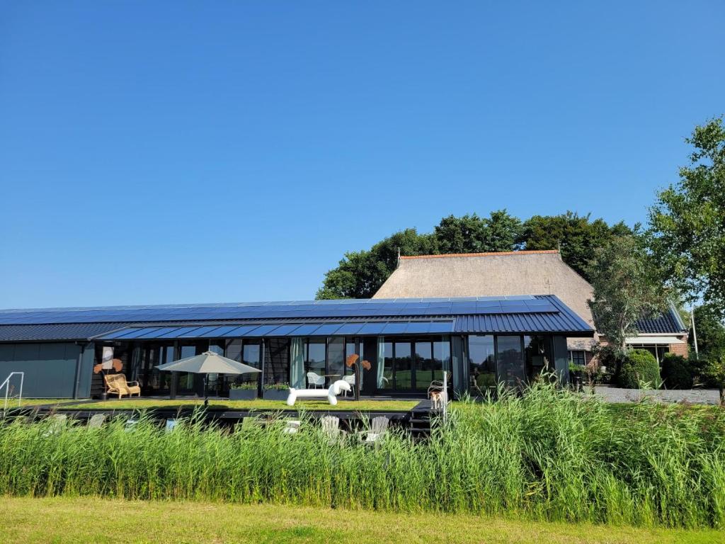 TietjerkHippe Schuur的一座带屋顶温室的房子