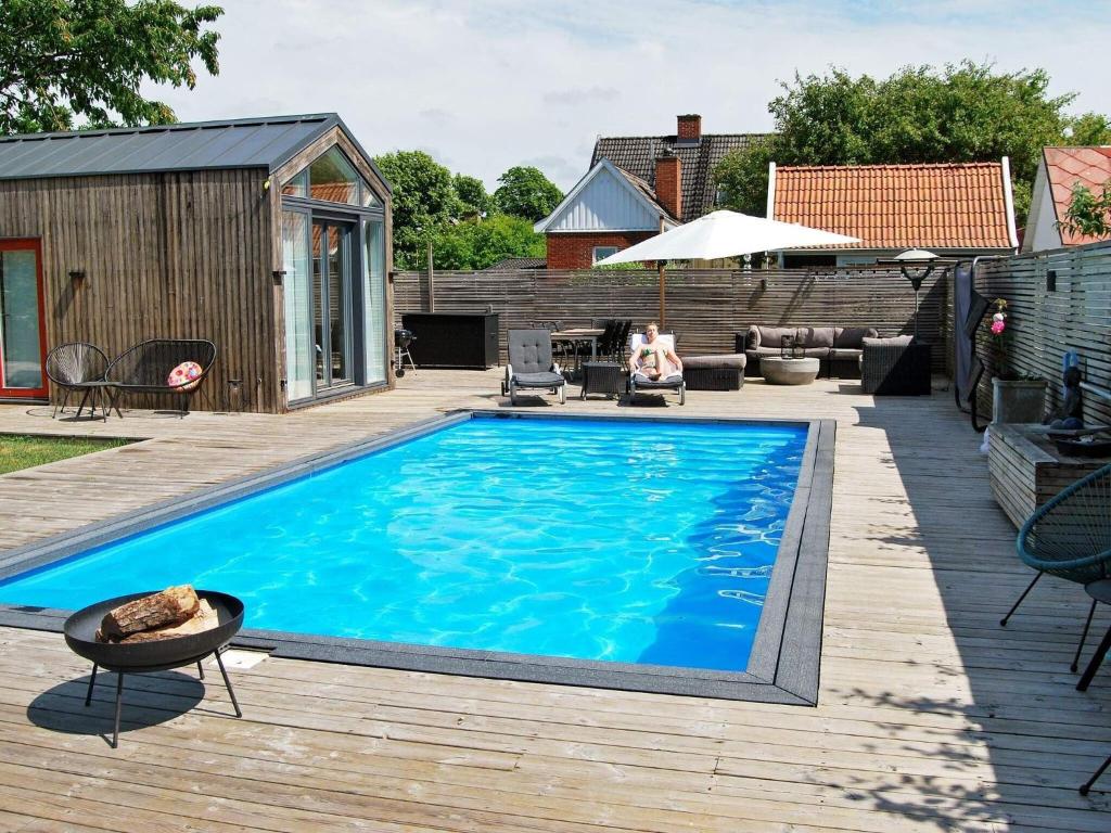 马尔默4 person holiday home in MALM的房屋旁的木甲板上的游泳池