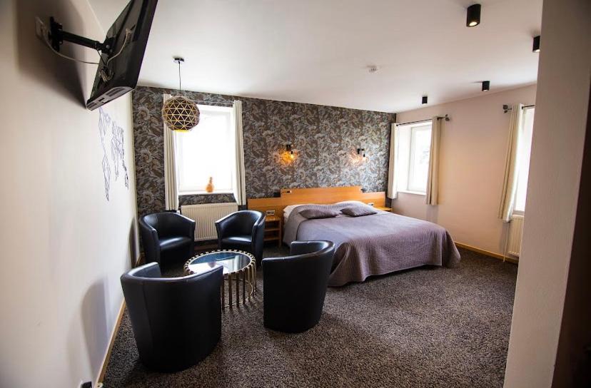巴拉特里乐斯卡佩德酒店的一间卧室配有一张床、椅子和电视